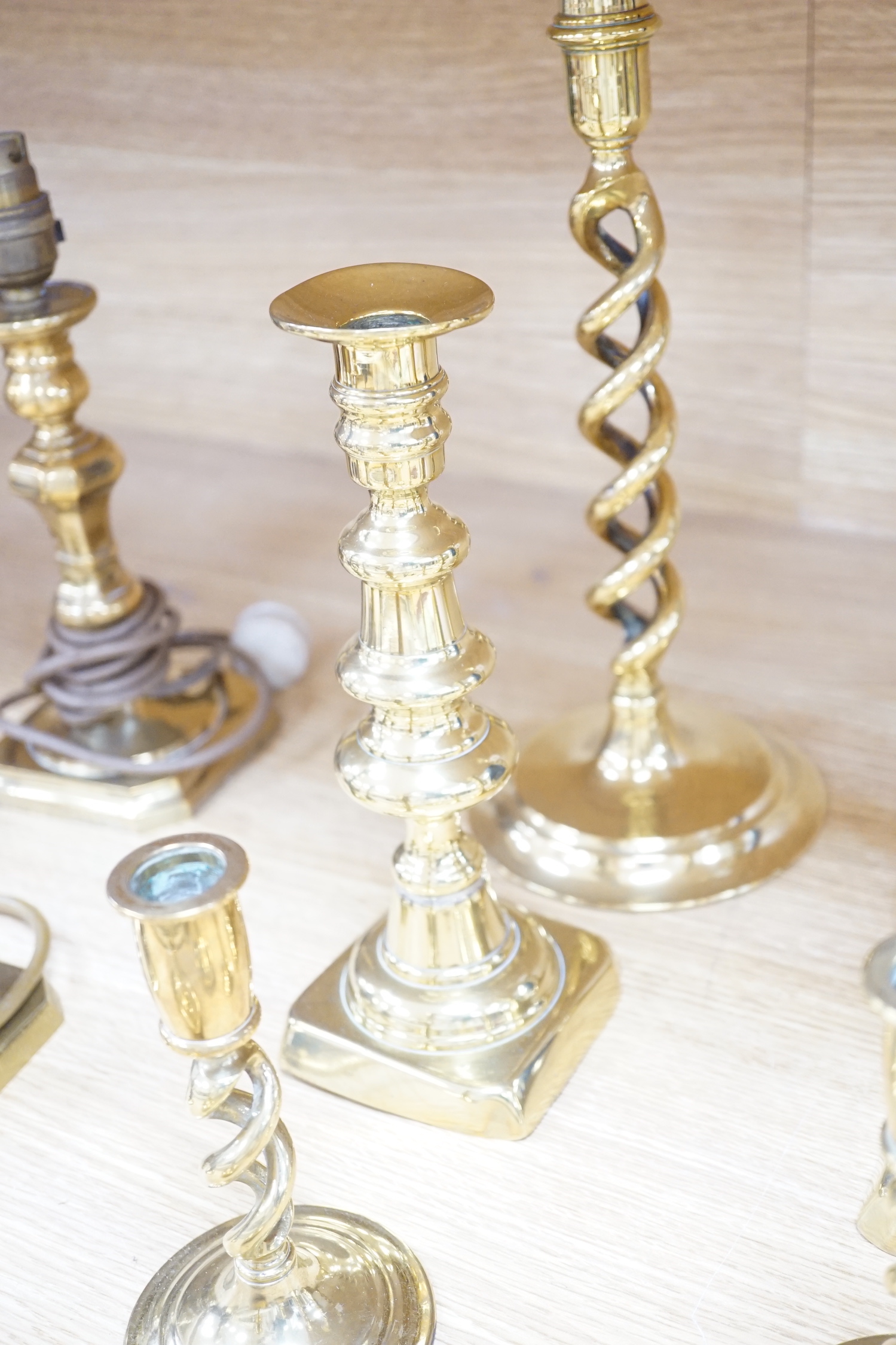 Four pairs of brass candlesticks, and another three converted to lamps, tallest 31cms high